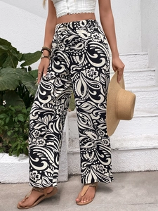 Close-up of high-waist wide-leg trousers featuring artistic black and white paisley floral patterns