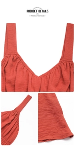 Detail view of the rust red sleeveless top featuring V-neck pleats and woven fabric texture