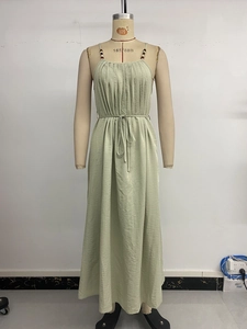 Detail of sage green maxi dress featuring beaded straps and fine pleated fabric texture
