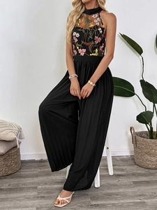 Detail of floral embroidery on halter neck mesh and pleated wide-leg jumpsuit