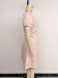 Détail de l'imprimé floral rouge sur robe blanche avec manches bouffantes et volants