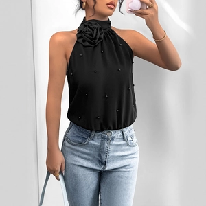 Black halter bodysuit with 3D rose and pearl accents paired with light wash denim jeans