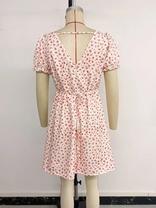 Détail d'une robe fleurie avec dos nu en V et manches courtes à volants
