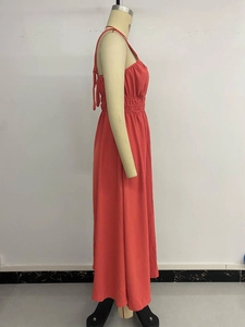 Detail of coral red backless midi dress with adjustable tie straps and pleated waist