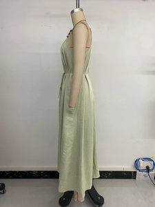 Detail of light green maxi dress showing waist tie and colorful bead neckline detail