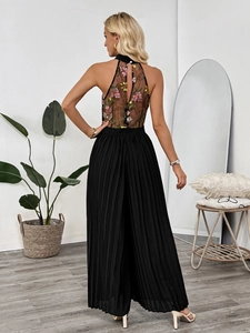 Elegant back detail of halter jumpsuit featuring pink floral embroidery and pleated black pants