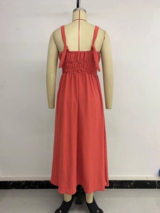 Detail of smocked elastic back and adjustable tie shoulder straps on orange maxi dress