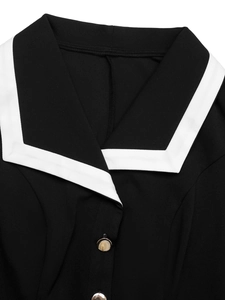 Close-up of contrast white sailor collar and metal button on a black dress