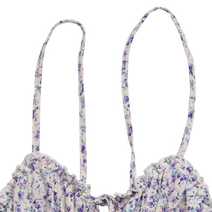 Détail du haut à fleurs à fines bretelles avec encolure à volants et cordon