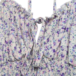 Détail de robe fleurie avec liens réglables au cou et bustier élastique froncé