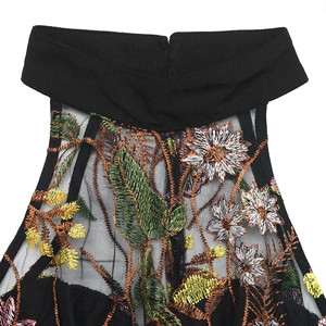 Detail of black halter neckline featuring intricate floral embroidery on sheer mesh fabric