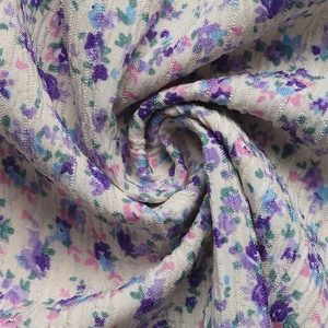 Gros plan du tissu floral avec texture tissée et fleurs colorées sur fond blanc cassé