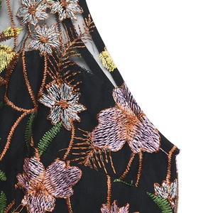 Close-up of intricate floral embroidery on black mesh fabric with vibrant color details