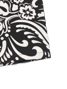 Detailed macro view of black and white paisley floral print fabric with hem stitching