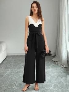 Detailansicht des schwarz-weißen Jumpsuits mit V-Ausschnitt und Taillengürtel-Schleife