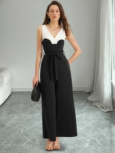 Detailansicht eines schwarz-weißen V-Ausschnitt Jumpsuits mit weitem Bein und Gürtel