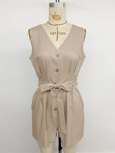 Detail view of the V-neckline with wood-style buttons and belted waist on jumpsuit