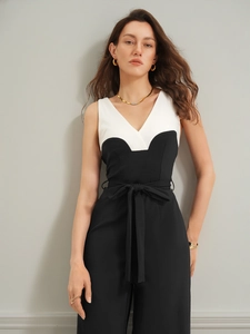 Detailansicht des V-Ausschnitts und Gürtels an einem ärmellosen schwarz-weißen Jumpsuit
