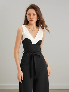 Detail des eleganten schwarz-weißen Jumpsuits mit tiefem V-Ausschnitt und Bindegürtel