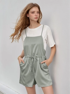 Detail der salbeigrünen gestreiften Jumpsuit mit Kordelzug und weißem T-Shirt