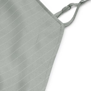 Detail von salbeigrünem Streifenstoff und verstellbarem Träger mit feiner Handwerkskunst