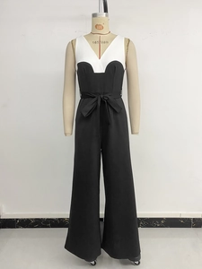Detailansicht des V-Ausschnitts und der Taillenschleife an einem schwarz-weißen Jumpsuit