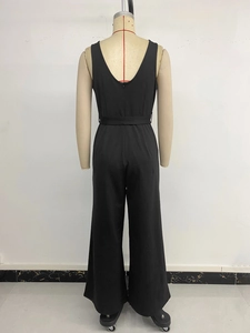 Detail des schwarzen ärmellosen Jumpsuits mit tiefem V-Rückenausschnitt und Taillengürtel
