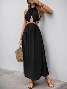 Détail de broderie ethnique bohème sur la taille d'une robe longue noire à découpes