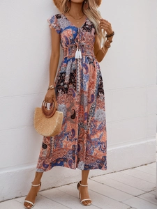 Détail d'une robe longue bohème à col en V avec imprimé ethnique et taille à pompons