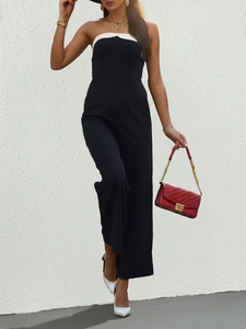 Detail of elegant black strapless jumpsuit with white trim and stylish wide leg cut