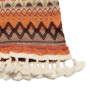 Détail de l'ourlet de robe en crochet coloré avec ondes géométriques et longues franges
