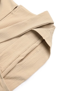 Close-up of khaki V-neck jumpsuit showing waffle texture fabric and fine stitching
