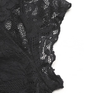 Gros plan sur la dentelle noire montrant les motifs floraux et les détails du col en V