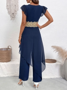 Dettagli della elegante tuta blu navy con pizzo dorato in vita e maniche a volant