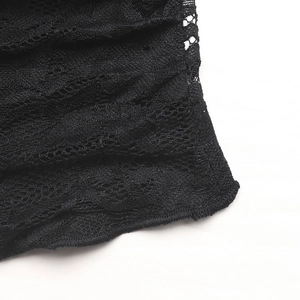 Détail de la texture en dentelle noire et des mailles ajourées du haut à col en V