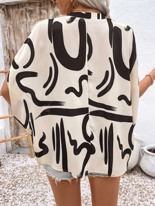Close-up of lightweight batwing sleeve blouse with black abstract geometric prints