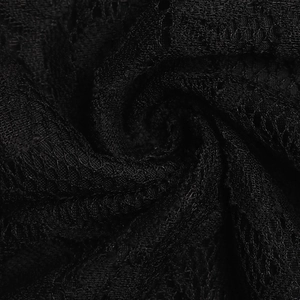 Gros plan sur de la dentelle noire montrant des textures florales et des détails résille