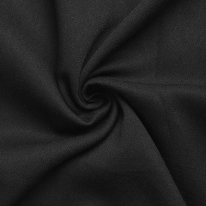 Détail macro de la texture du tissu sergé noir avec un élégant effet de drapé en spirale