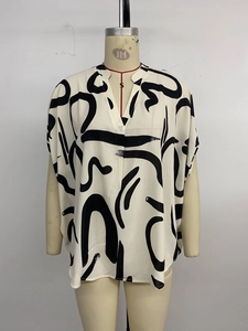Detail view of v-neck short sleeve blouse with black abstract geometric prints