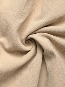 Detailed texture of beige pleated fabric with vertical wrinkles for summer jumpsuits