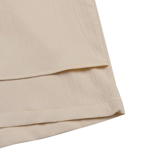 Macro detail of breathable beige seersucker fabric with double-layered hem stitching