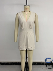Detail showing the elegant V-neckline and waist pleats of this beige sleeveless romper