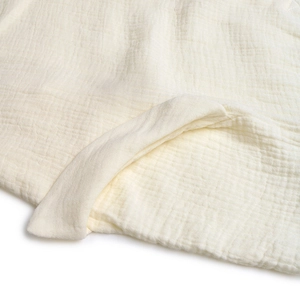Gros plan sur le tissu gaufré en coton crème montrant les détails de texture douce