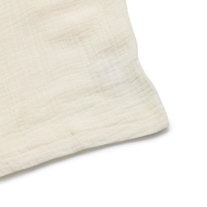 Détail macro du tissu en gaze de coton blanc crème avec finition de couture fine