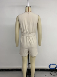 Detail view of the back of a beige sleeveless romper with elastic waist and hidden zipper