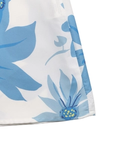 Detailed close-up of floral print fabric with fine stitching on white summer skirt