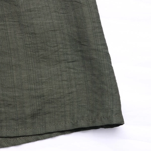 Close-up of military green jumpsuit showing premium fabric texture and neat hem stitching