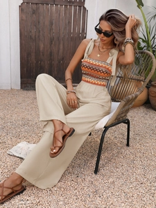 Detail of bohemian jumpsuit featuring a smocked bodice with vibrant geometric ethnic patterns