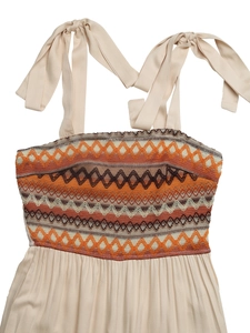 Detail of bohemian embroidery and adjustable tie straps on a beige summer jumpsuit