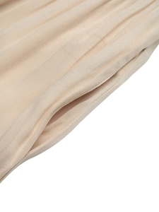 Detailed close-up of side pocket and premium light beige woven fabric on summer jumpsuit